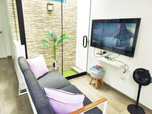 a living room with a couch and a tv at Departamento Moderno - Zona Exclusiva - Huacachina in Ica
