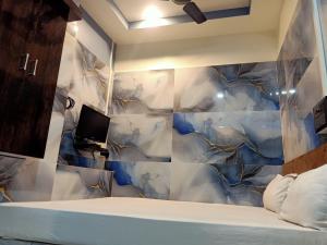 a bedroom with a blue and white tiled wall at Paribartan Hotel & Lodge in Farakka