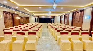 a banquet hall with rows of chairs and a stage at Srivari Homestay in Tirupati
