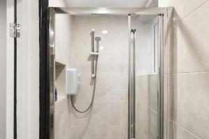 a shower with a glass door in a bathroom at Convenient Studio and Parking Easy Access Cntr London in Perivale