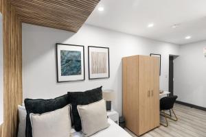 a bedroom with a bed with black and white pillows at Convenient Studio and Parking Easy Access Cntr London in Perivale