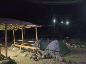 a tent in the sand at night at Rickson Riverside Campsite in Dawki +2 photos
