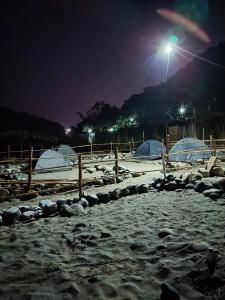 a snow covered field at night with a street light at Rickson Riverside Campsite in Dawki