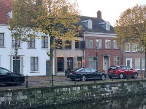 a group of cars parked in front of buildings at Herenhuis aan het water in centrum Sluis in Sluis