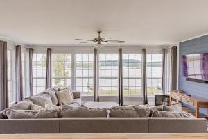 a living room with a large couch in front of windows at All Seasons Resort with Lake Access in Georgetown