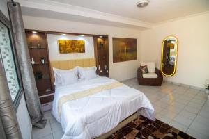 a bedroom with a large bed and a mirror at A2G Apartments in Douala
