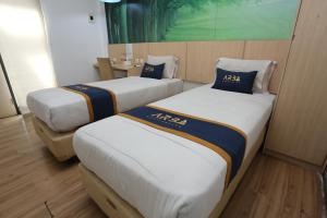 2 letti in una camera d'albergo con sidro sidx sidx sidx di King Stone Hotel By ARBA a Kranggan-wetan Satu