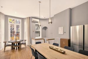 a kitchen and dining room with a table and a refrigerator at Outsite Chelsea in New York +34 photos