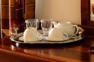 a tray with a tea set and glasses on a table at Mokoro Lodge in Maun
