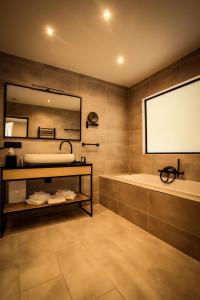 a bathroom with a tub and a large mirror at Ferme d'Ecavée in Celles +13 photos