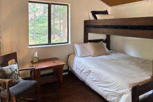 a bedroom with a bed and a chair and a window at Pine Hill Hideaway in Stateline