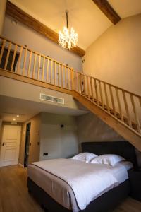 a bedroom with a large bed with a staircase at Ferme d'Ecavée in Celles