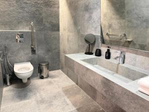 a bathroom with a toilet and a sink at Gloria Hotel in Szack +54 photos