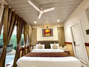 a bedroom with a bed and a ceiling fan at Naini Lake View The- Gwen -Stays Mall Road - Lake View Rooms Types- Prime Location - Best Luxuary Hotel In Nainital in Nainital