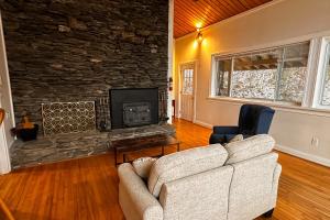 a living room with a couch and a fireplace at Middle Pines Chalet in Warren