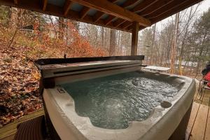 a hot tub with a wooden roof on a deck at Middle Pines Chalet in Warren