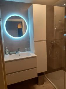 a bathroom with a sink and a shower with a mirror at Residentie Strand in Blankenberge