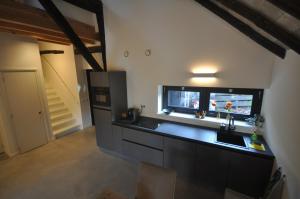 a kitchen with a black counter top and a window at Hoeve 't Peerdeke in Breda