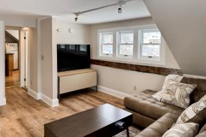 Una sala de estar con un sofá y un televisor de pantalla plana. en Stowe Mountain Road Retreat, en Stowe