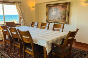 een eetkamer met een tafel en stoelen en een schilderij bij La Casa De La Playa in Lanesville +30 foto's