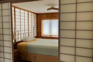 een slaapkamer met een bed en een raam bij La Casa De La Playa in Lanesville