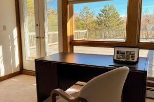 een bureau met een laptop en een stoel bij La Casa De La Playa in Lanesville