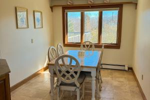 een eetkamer met een tafel en stoelen en een raam bij La Casa De La Playa in Lanesville