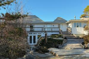 een wit huis met een trap daarheen bij La Casa De La Playa in Lanesville