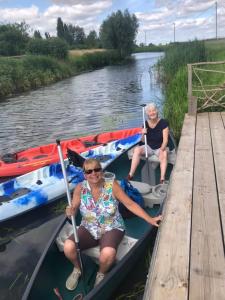 Zwei Frauen sitzen in Kanus auf einem Fluss in der Unterkunft Home Thyme Holding in Upwell