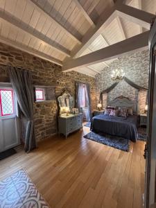 una camera da letto con un letto e un muro di pietra di Casa de Carmen Bañera, chimeneas de leña y terraza a Corcubión