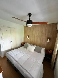 a bedroom with a white bed with a ceiling fan at Puerta Azul in Punta del Este