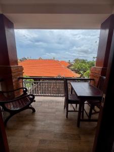Un balcón con mesa y sillas y una vista en Kubu alit guest house Seminyak, en Seminyak