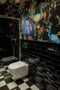 a bathroom with a toilet and a colorful wall at The Loft Life in Tríkala