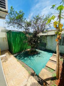 a small tree in front of a green fence at Casa Cataratas in Foz do Iguaçu