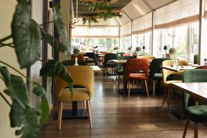 ein Restaurant mit Tischen, Stühlen und Pflanzen in der Unterkunft Hotel Medemblik in Medemblik