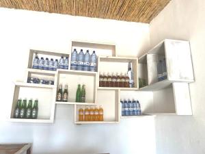 a bunch of bottles on shelves on a wall at Akagera Able Lodge in Akagera