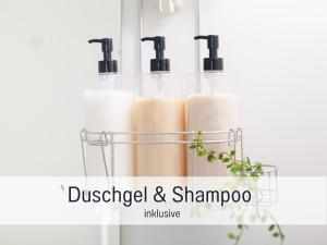 a glass holder with three bottles of disinfected and shampoo at Alpenstudio Sachrang - Terrasse & Bergblick - Ruhe & Natur pur in Aschau im Chiemgau +28 photos