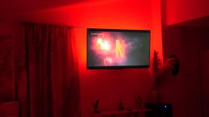 a tv in a red room with the letter k on it at Monte d'Oro Rooms in Scauri +57 photos