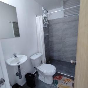 a bathroom with a white toilet and a sink at Apartamento Completo en Ricaurte in Ricaurte