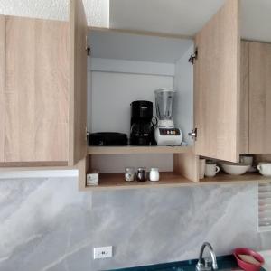 a kitchen with wooden cabinets with a blender on it at Apartamento Completo en Ricaurte in Ricaurte