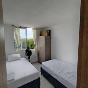 a bedroom with two beds and a window at Apartamento Completo en Ricaurte in Ricaurte