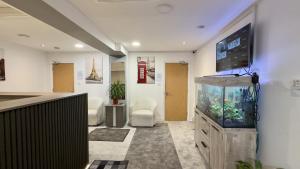 a room with a fish tank and a tv on a wall at Heathrow Travellers Hub in Hounslow