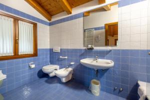 a blue tiled bathroom with a sink and a toilet at Contra' Contarini in Campolongo Sul Brenta +56 photos