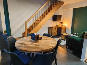 a room with a table and chairs and a staircase at Apartmán 19 MEZONET in Jáchymov