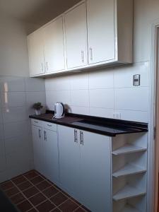 a kitchen with white cabinets and a counter top at GuestHouse Habitaciones SANTIAGO CENTRO in Santiago