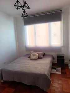a bed in a bedroom with a large window at GuestHouse Habitaciones SANTIAGO CENTRO in Santiago