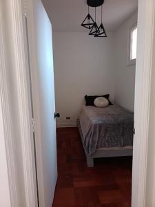 a small bedroom with a bed and a chandelier at GuestHouse Habitaciones SANTIAGO CENTRO in Santiago +3 photos