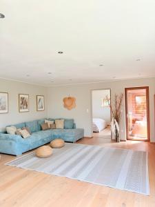 ein Wohnzimmer mit einem blauen Sofa und einem Teppich in der Unterkunft Seehaus 22- Lake house with private beach in Grafenwörth