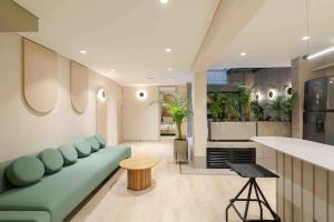 a living room with a green couch and a counter at Hotel Lincoln in Medellín