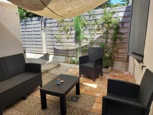 a small patio with two chairs and a table at Maison 6 personnes in Barbâtre +2 photos